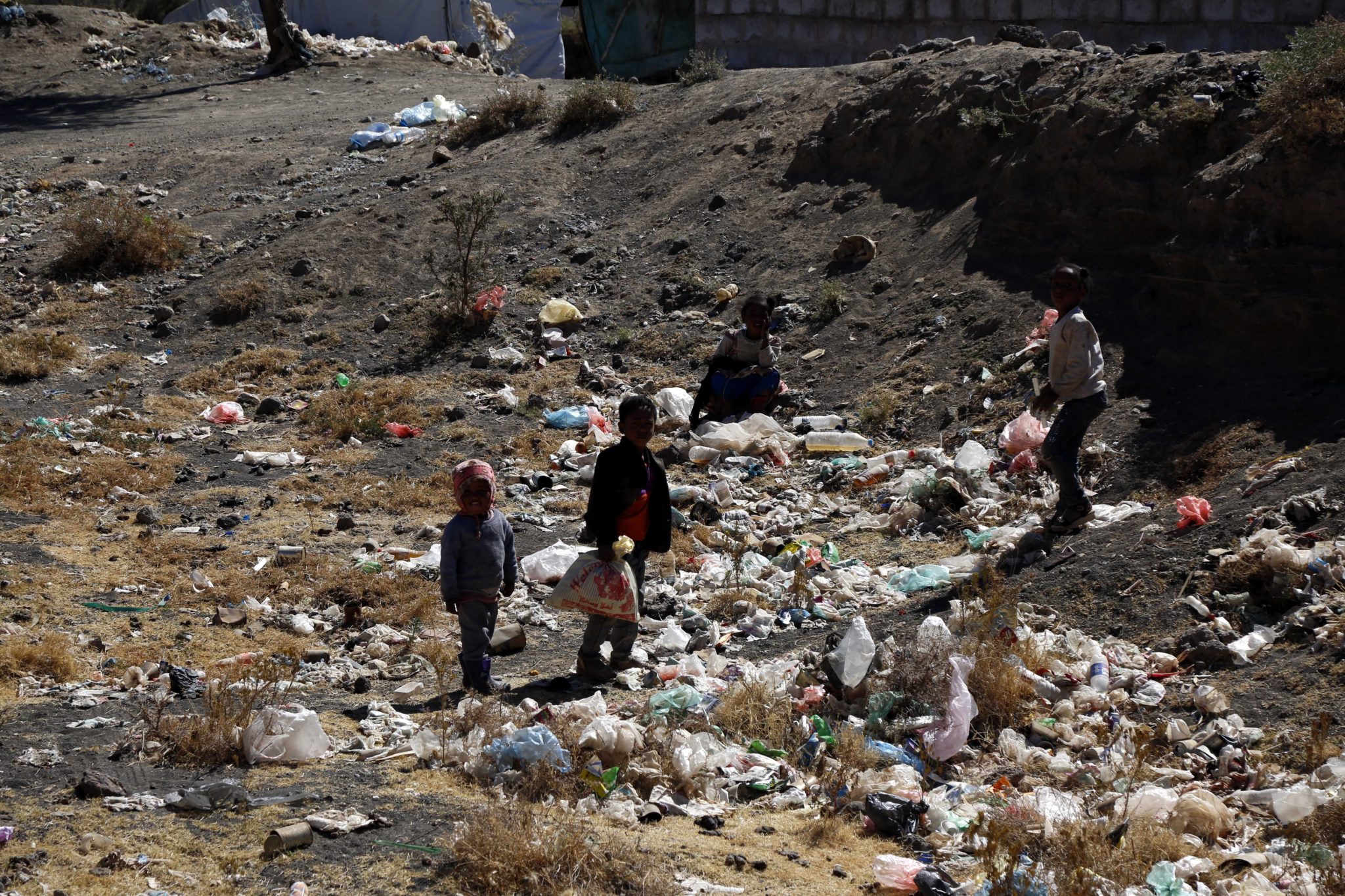 Children are seen among garbage at a displacement camp in Yemen 
