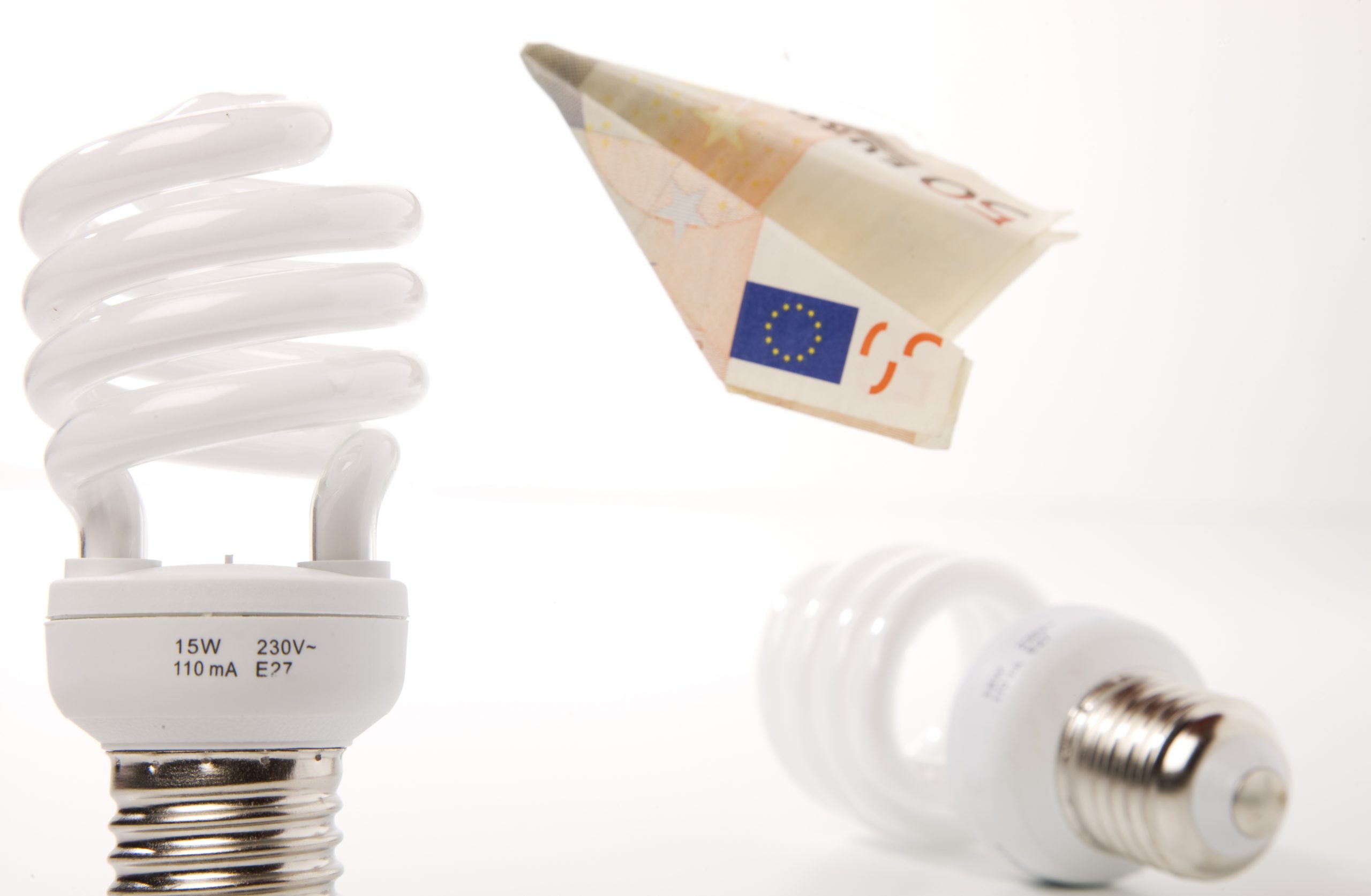 electricity. Image shows two lightbulbs with a €50 note folded into a paper aeroplane between them.