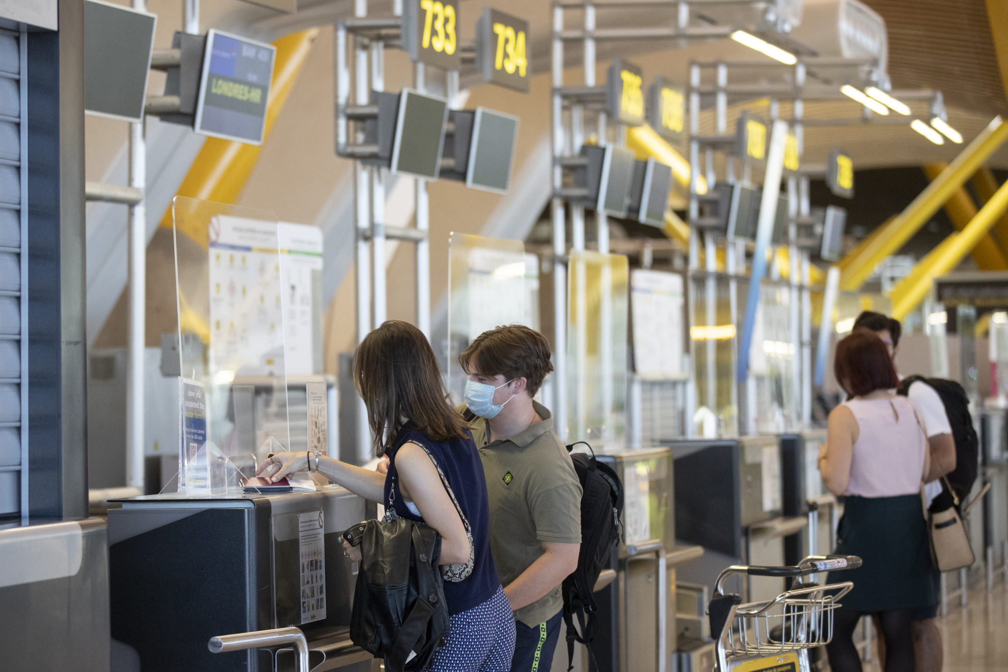 Passengers check in prior to departure for London at a British Airways check-in desk at Adolfo Suarez-Barajas international airport on the outskirts of Madrid, 26-07-2020. Image: Manu Fernandez/AP/Press Association Images