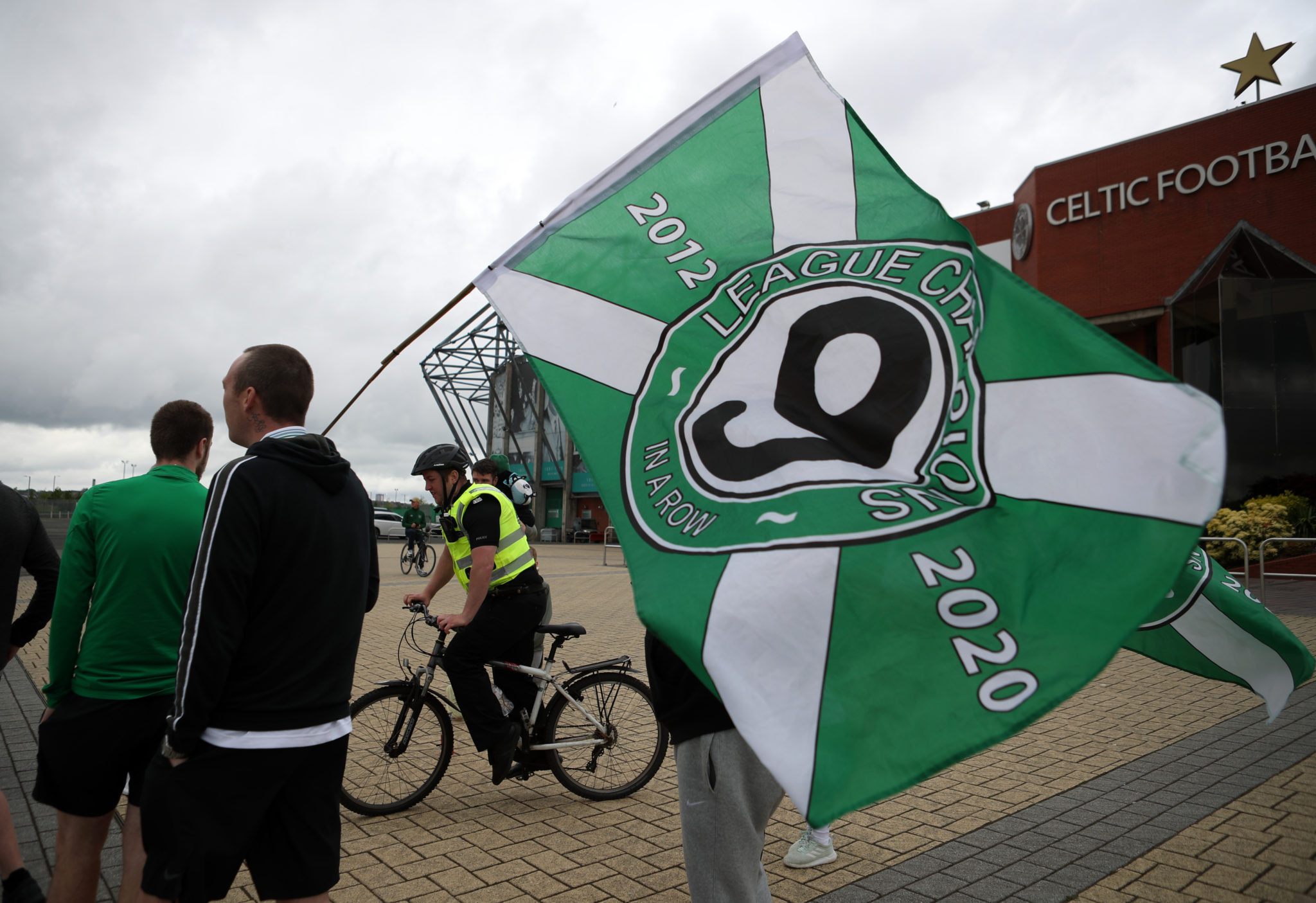 Celtic fans with a Celtic flag outside Parkhead