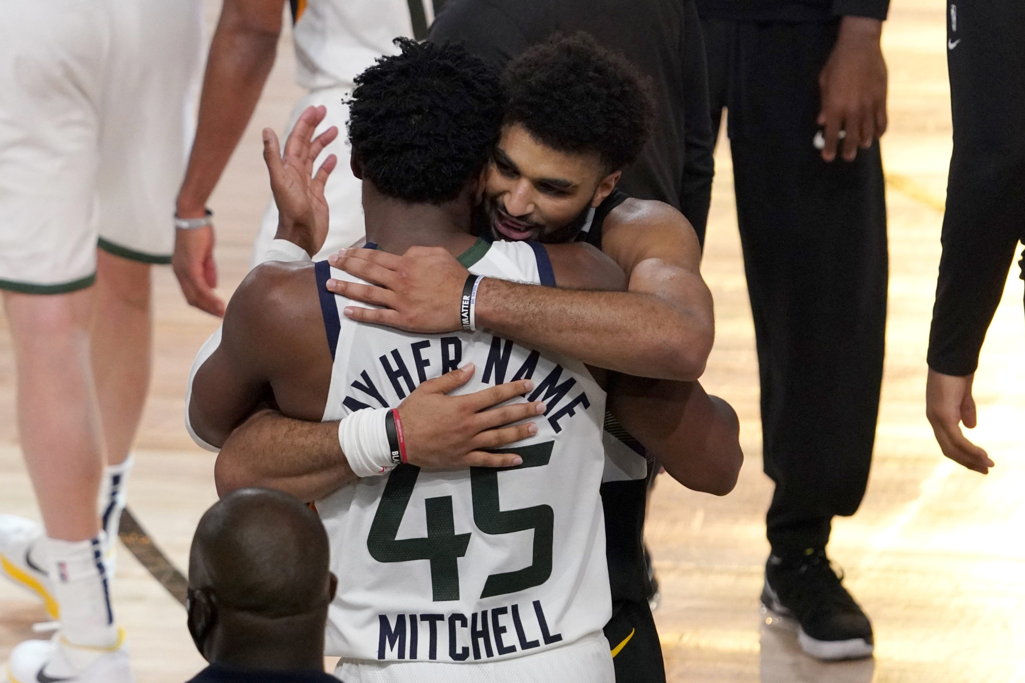 Jamal Murray and Donovan Mitchell embrace after their NBA first round playoff basketball game.