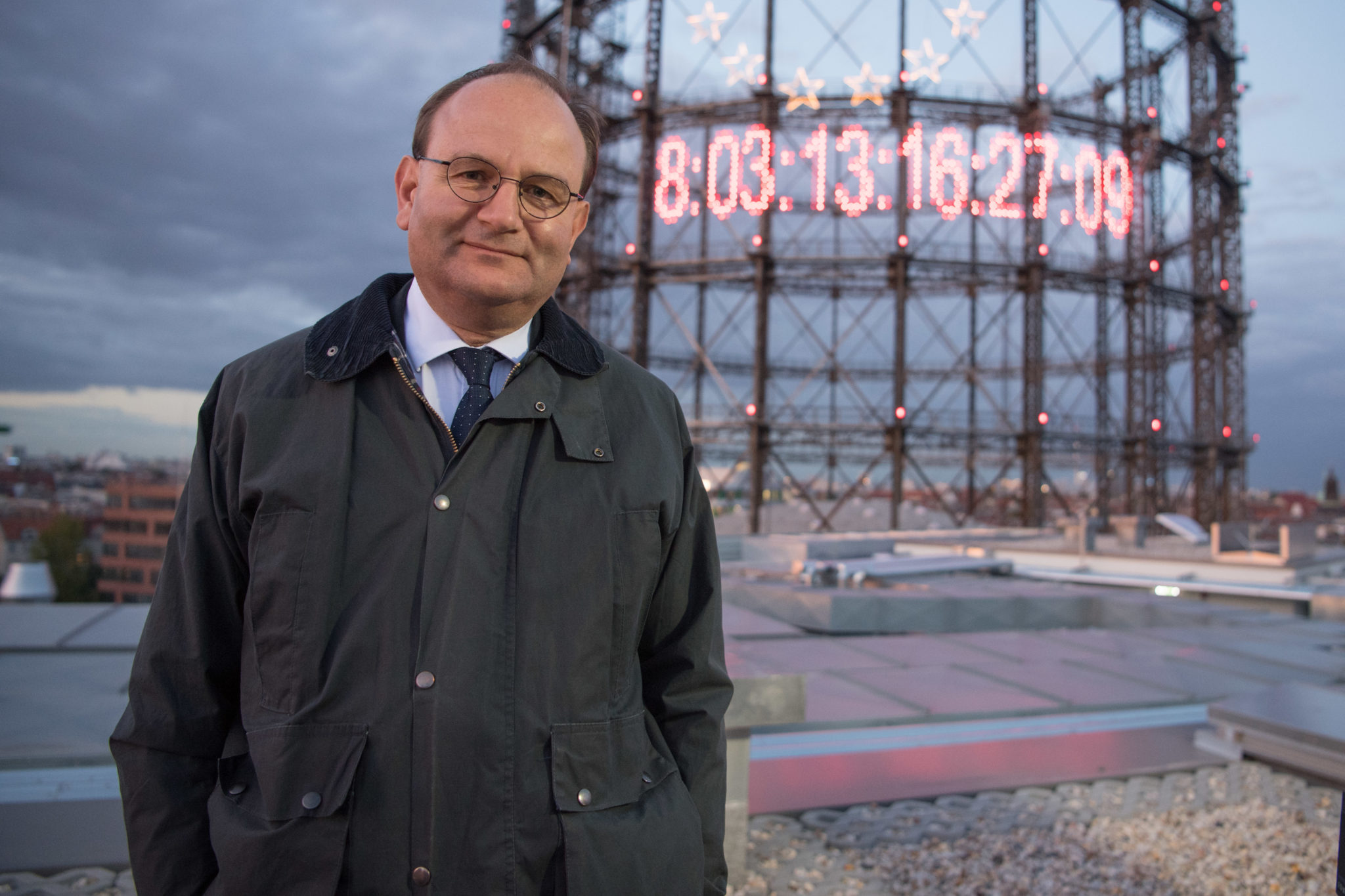 Climate researcher Professor Ottmar Edenhofer stands in front of a CO2 clock attached to a gasometer REthink Energy