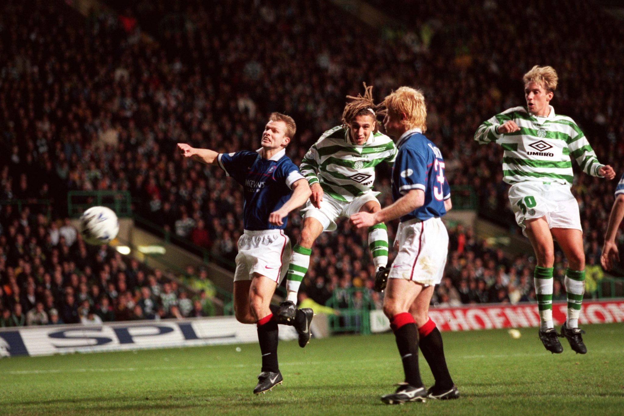 Henrik Larsson of Celtic scores against Rangers