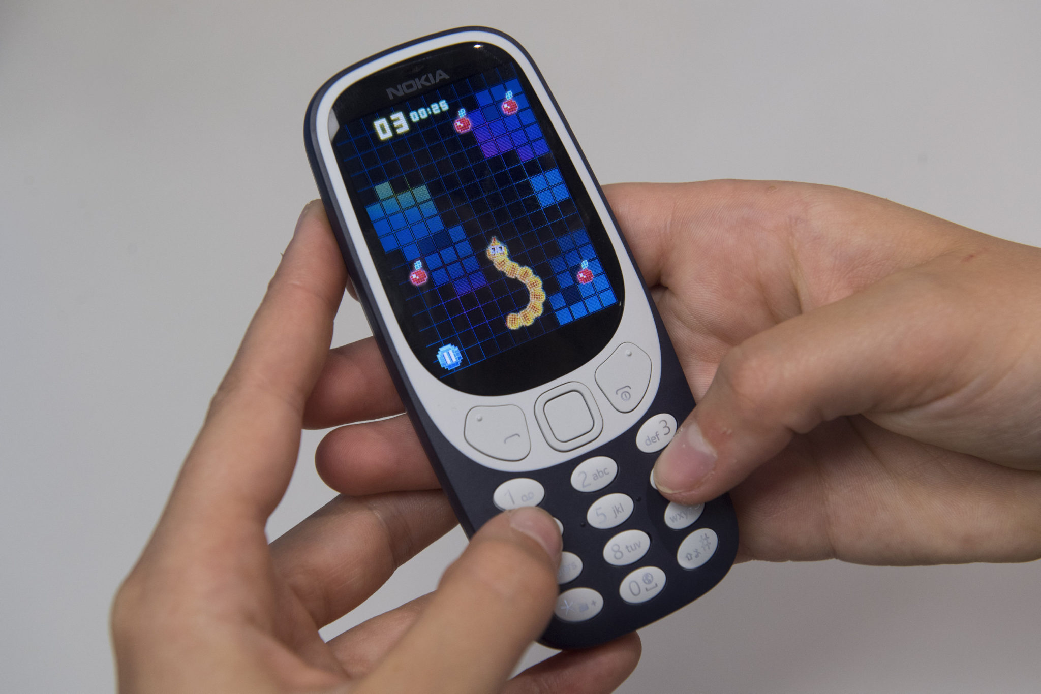 Someone playing mobile game snake on a Nokia phone