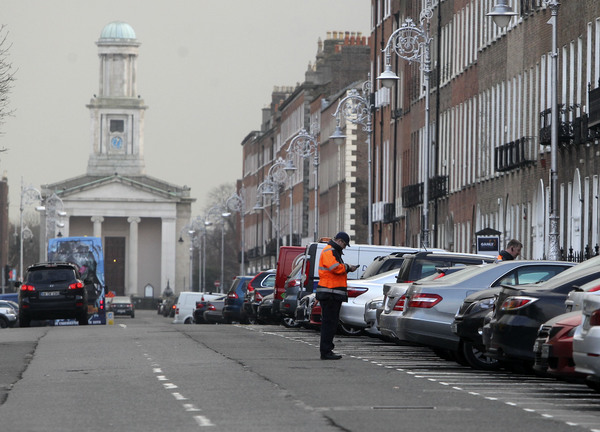 A Dublin City Council worker in the clamping department looks at a car on Merrion Square in Dublin 30-1-14.