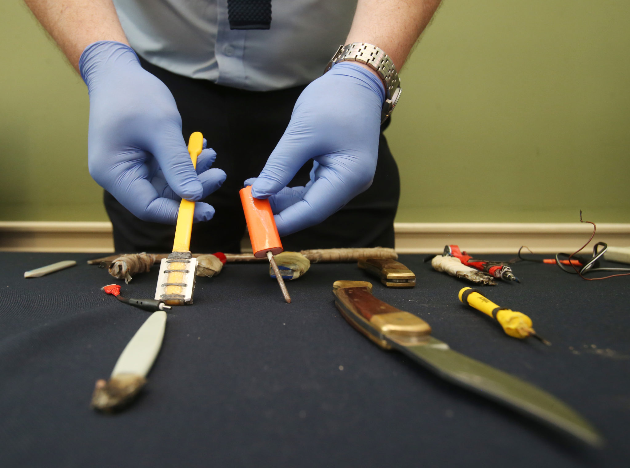 A prison officer shows weapons confiscated in prison