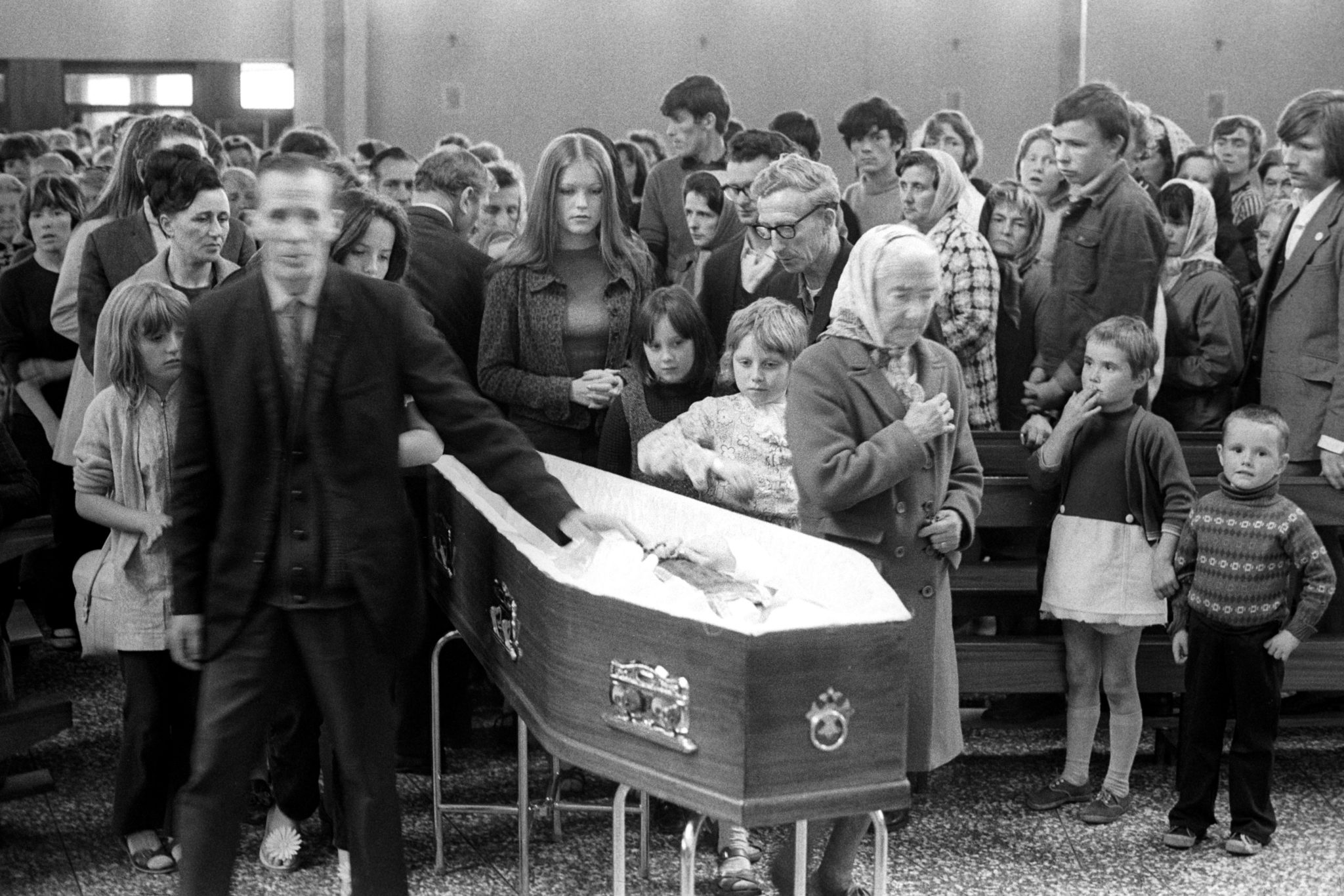 Mourners file past the coffin of Fr Hugh Mullan, at Corpus Christi Roman Catholic Church on the Ballymurphy estate in Belfast, on August 11th 1971. He was killed after attempting to give last rites to a wounded parishioner. 