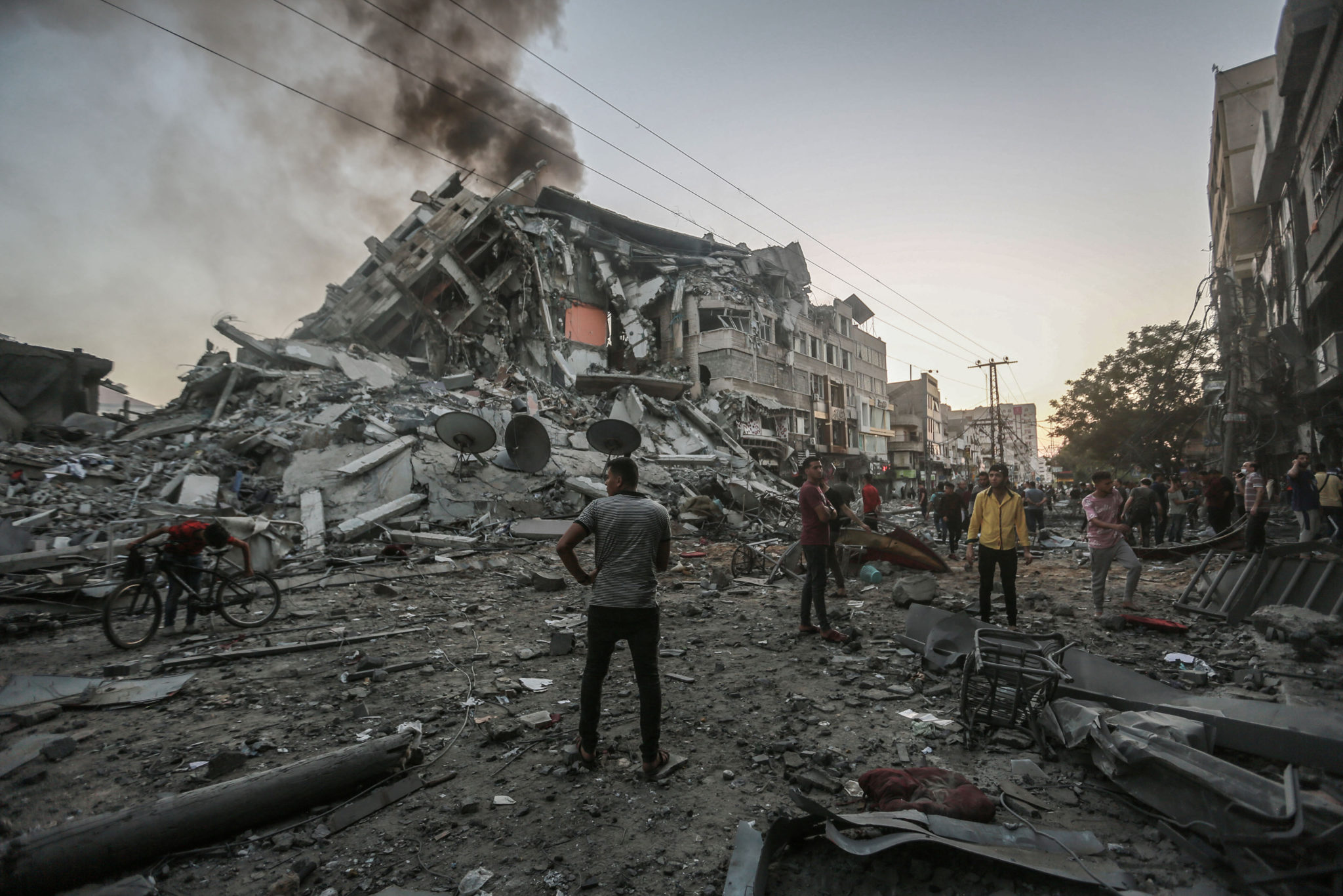 People inspect the site of the collapsed Al-Shorouk Tower building after it was hit by an Israeli airstrike