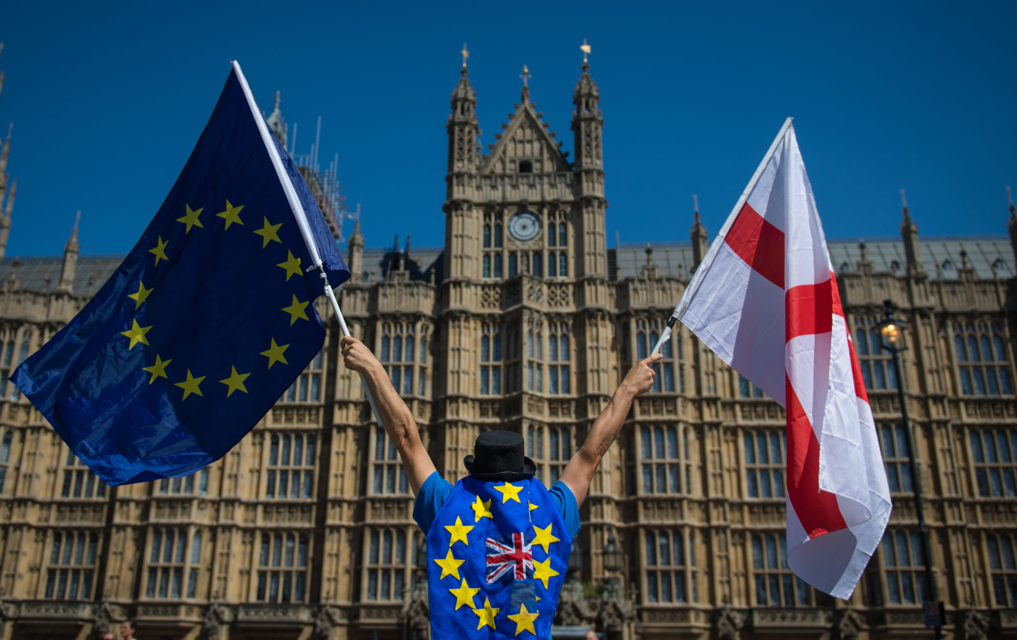 an anti-Brexit demonstrator holding European Union and England flags outside the Houses of Parliament, in central London. The UK and EU have reached a post-Brexit trade agreement.