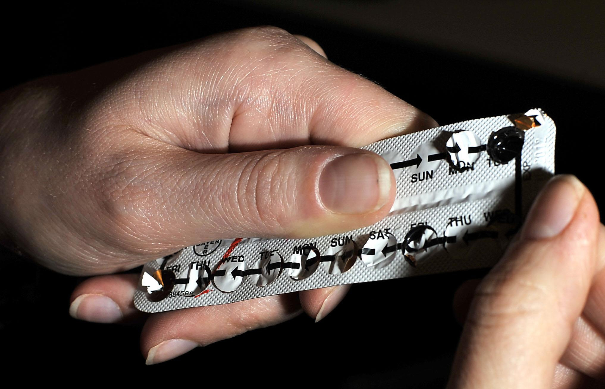 A woman holds a packet of contraceptive pills
