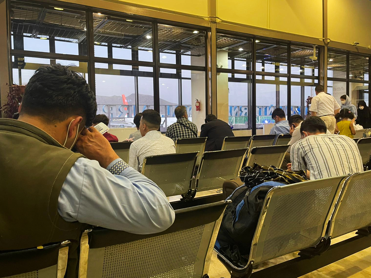 Passengers trying to fly out of Kabul International Airport wait in the terminal in Kabul, Afghanistan on Friday, August 13th 2021.