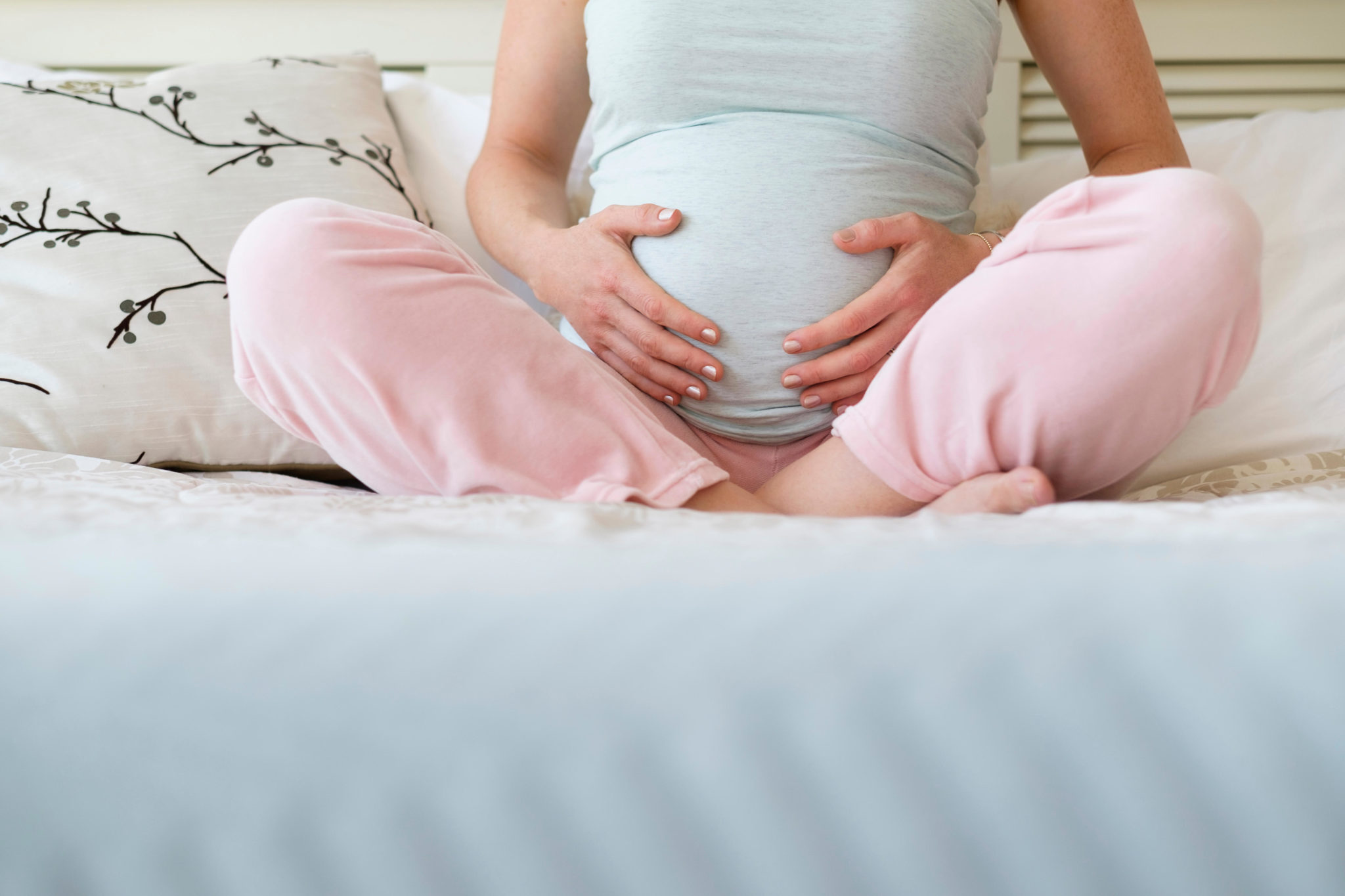 Pregnant woman sitting on bed