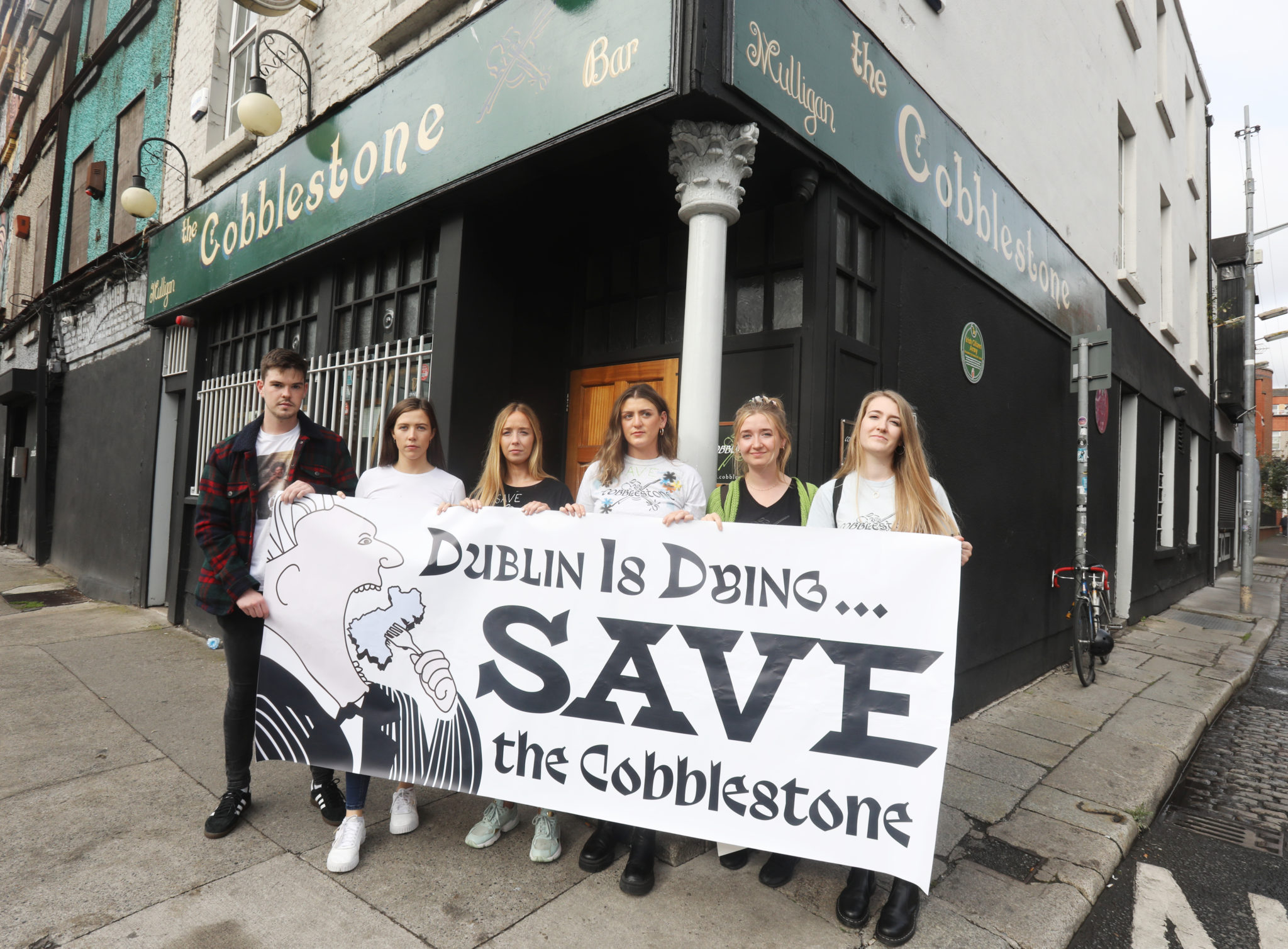 Protesters outside the Cobblestone pub in Dublin, with a sign calling for the popular pub to be saved