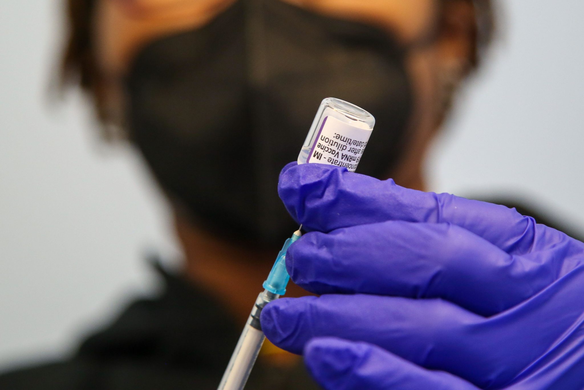 A healthcare worker prepares a booster vaccine