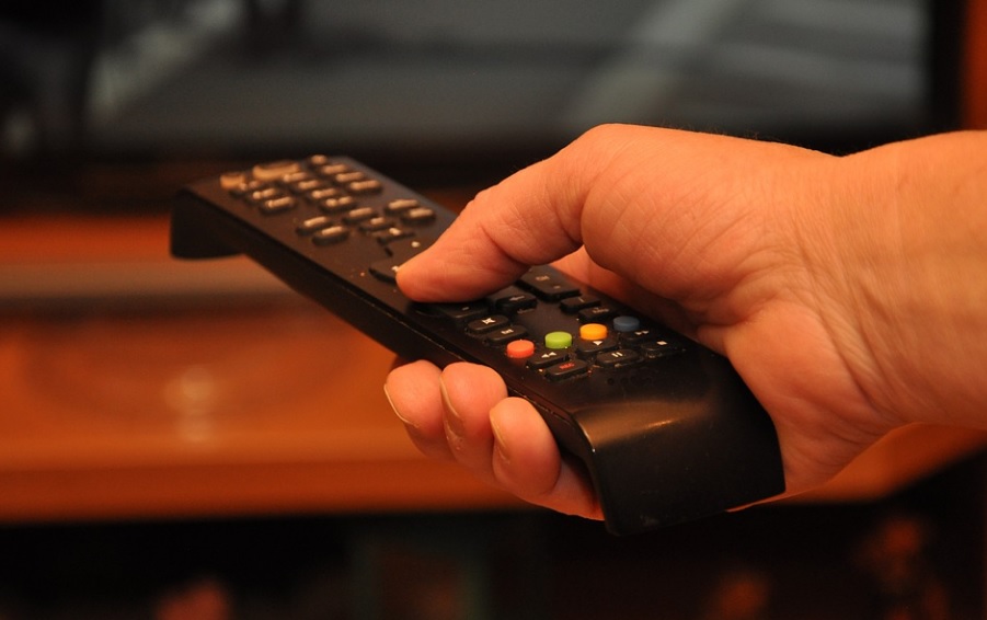licence fee. Image shows a white hand holding a television remote