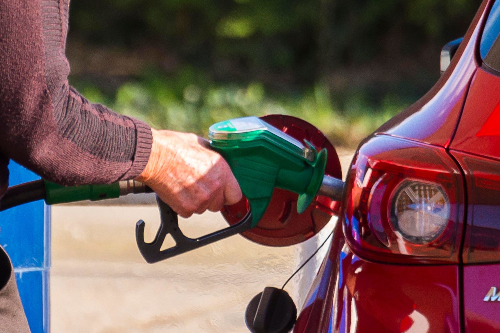 A man filling his car up with fuel at a petrol station in February 2022