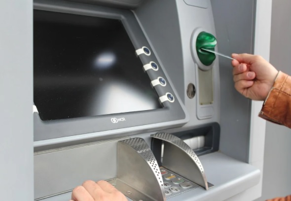 ATM raids. Image shows a hand putting in a bank card into an ATM.