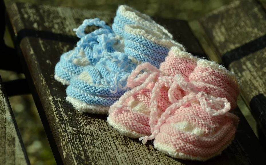 illegal adoptions. Image shows two pairs of baby shoes, one in pink and the other in blue.