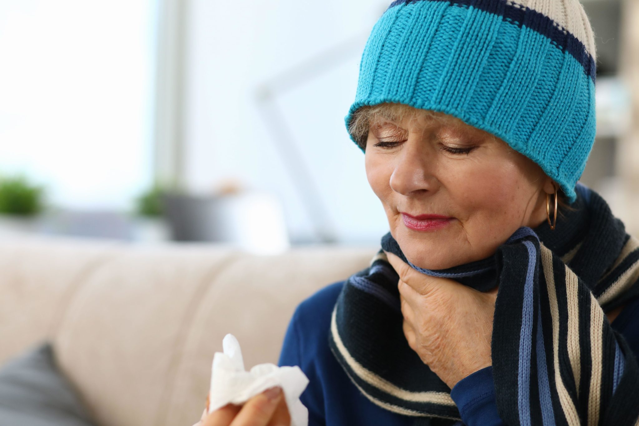 Sick lady touching sore throat. Image: Hanna Kuprevich / Alamy Stock Photo