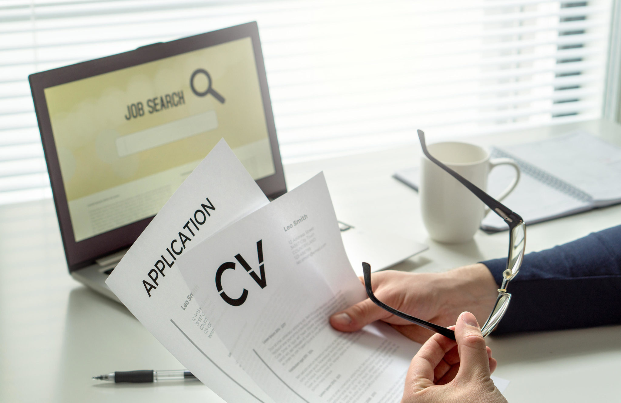 A job seeker is seen in a home office with a CV and job application form.