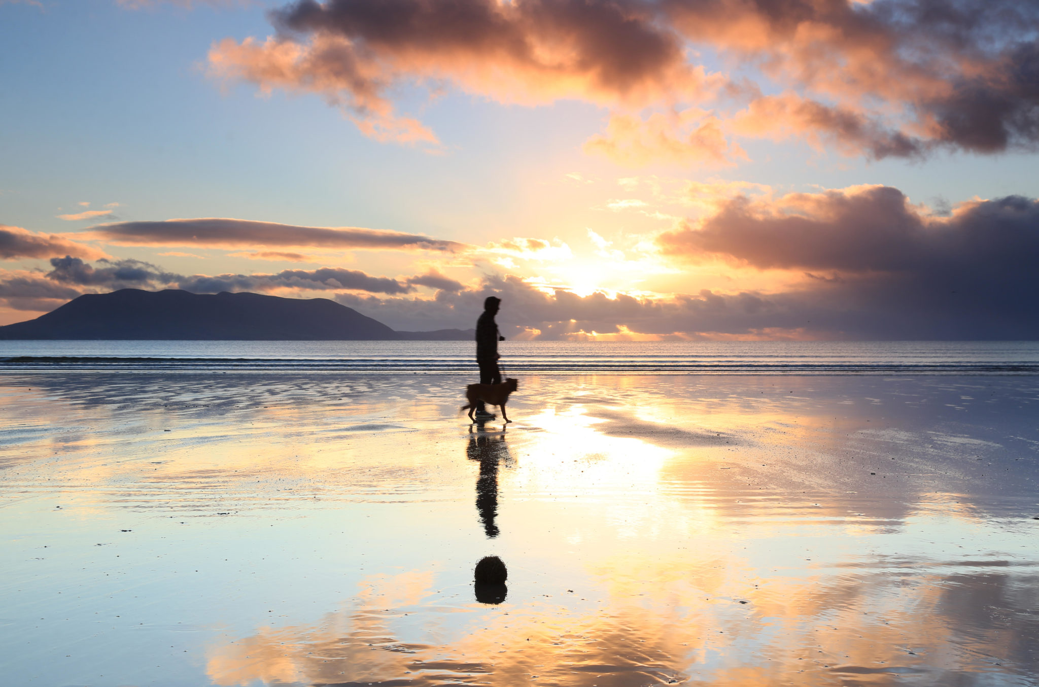Scenic view over water in Ireland with man and dog. ImagE: Image: Michael Diggin / Alamy Stock Photo