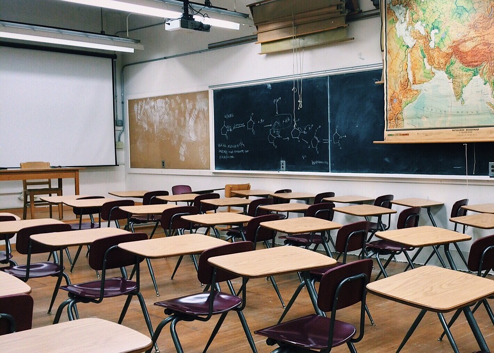 CAO. Image shows rows of desks in a classroom.