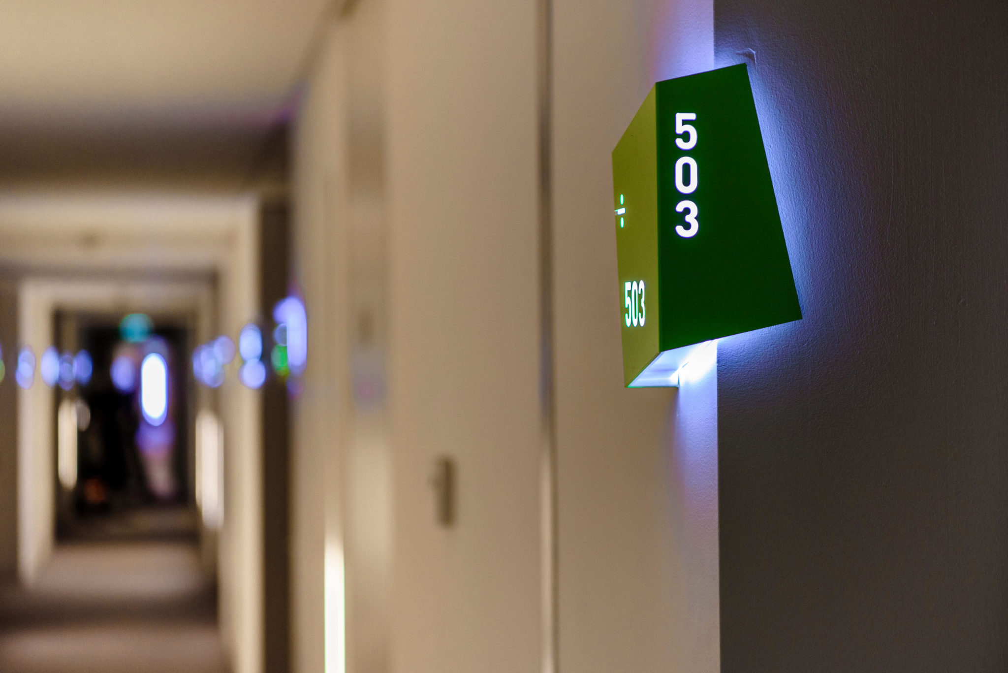 Room lights are seen outside rooms along a corridor in a hotel in 2017.
