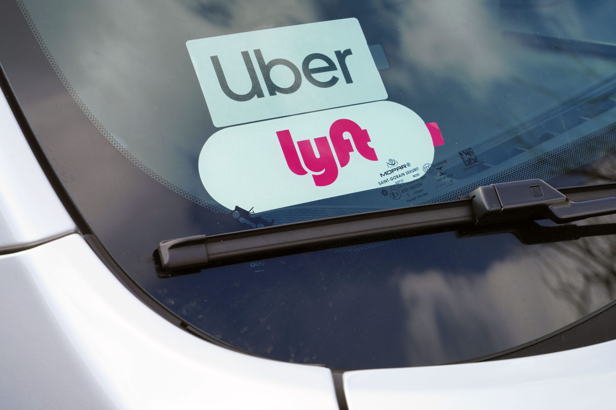 A car with stickers for both the Uber and Lyft ride share service is seen in the US in April 2020. 