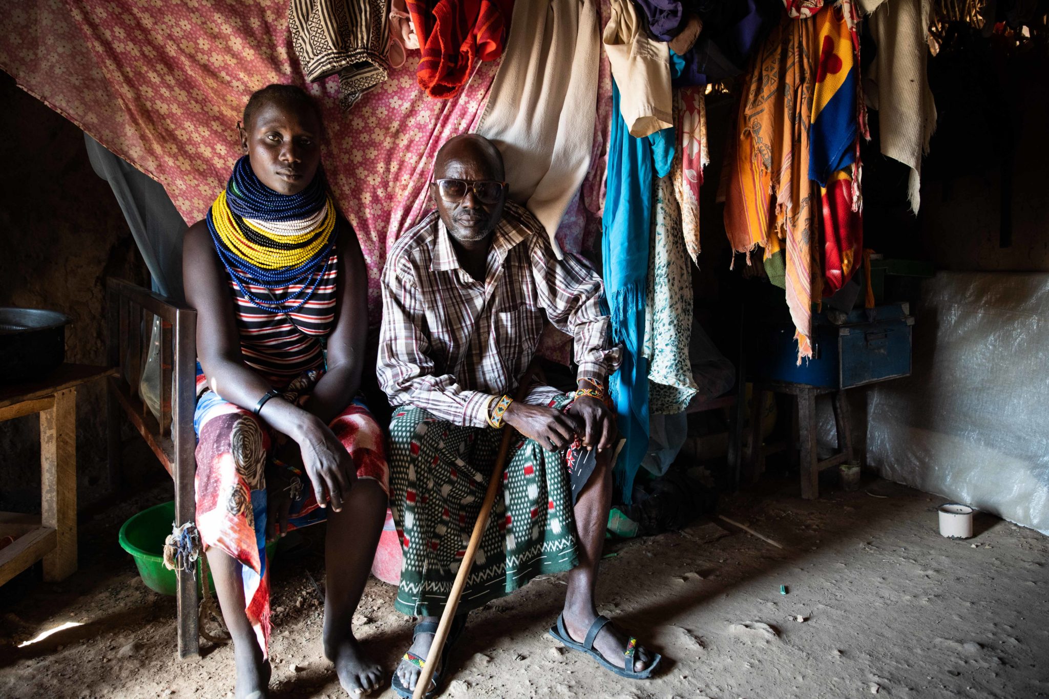 Pastoralist Richard Ekale Nakalale, who lost his sight in 2020, and his wife pose for a photo at their house in Milimatatu Village, Kaeris, Turkana County in Northern Kenya, 27-06-22. Image: Lisa Murray/Concern Worldwide.