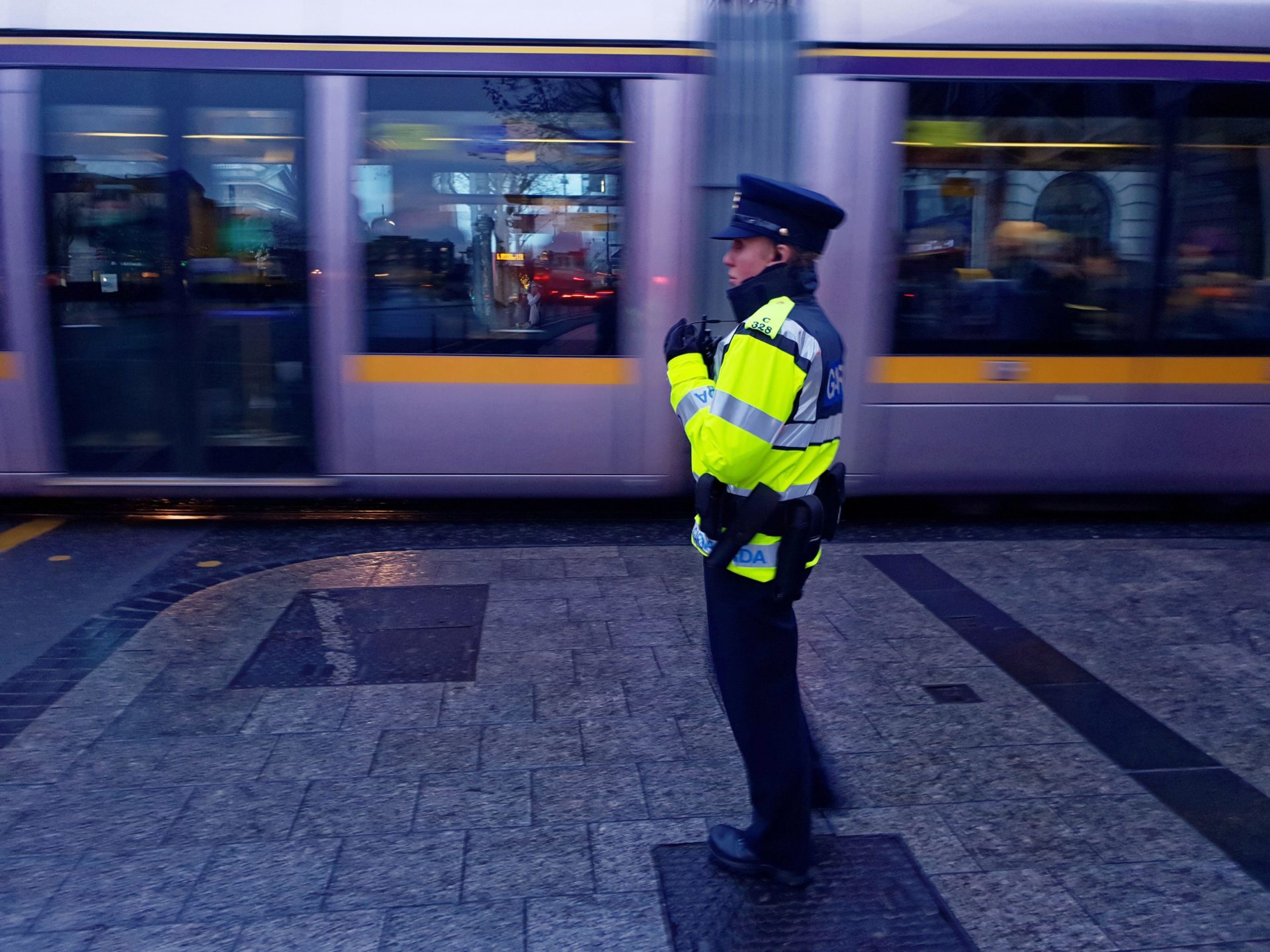 A Garda on duty in Dublin city centre, with a moving Luas in the background, in December 2019.