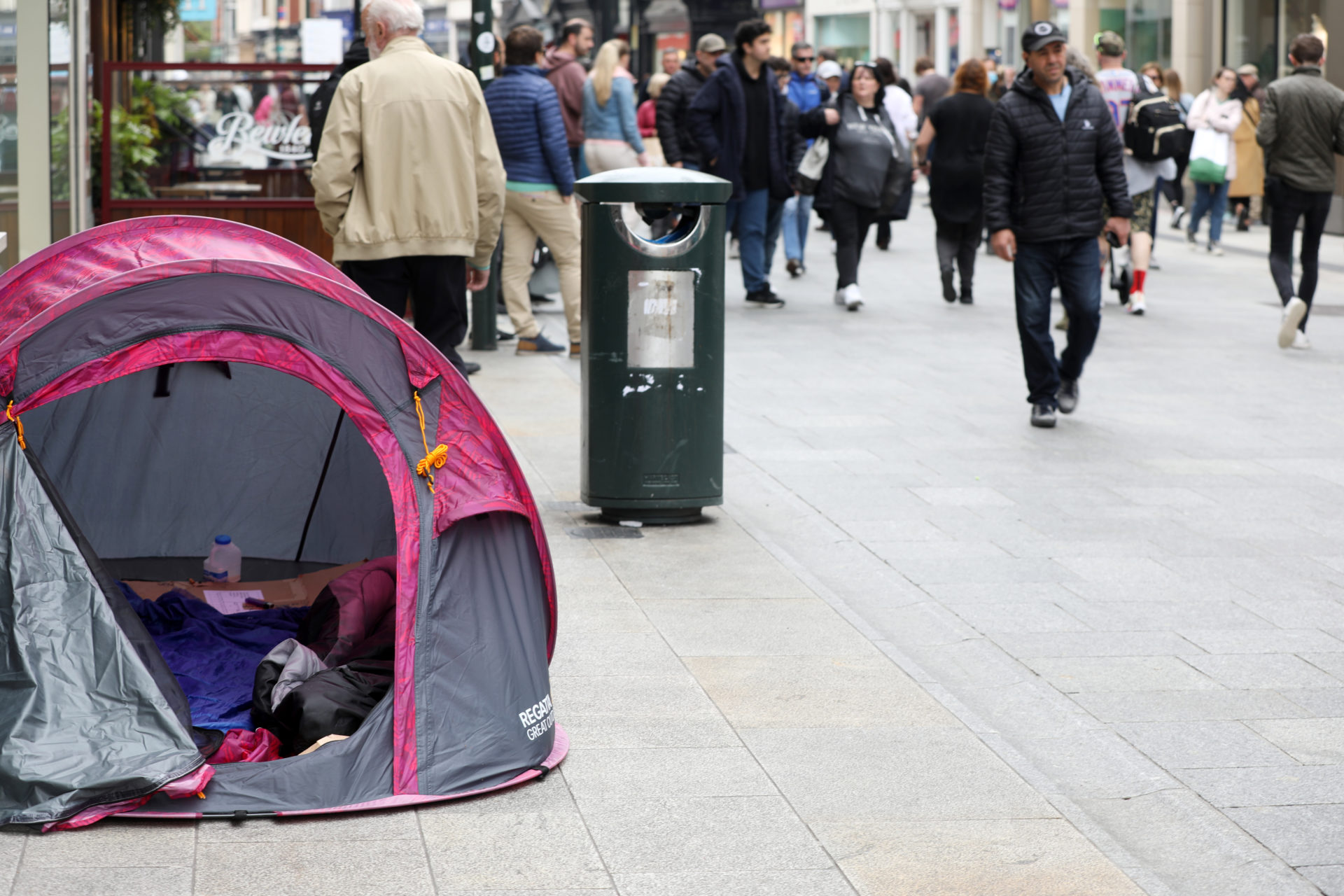 People sleeping rough in a tent on Grafton Street Dublin as shoppers walk past, 07-05-2022. Image: Leah Farrell/RollingNews