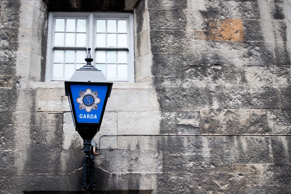 death. Image shows a blue Garda lamp on a grey stone wall.