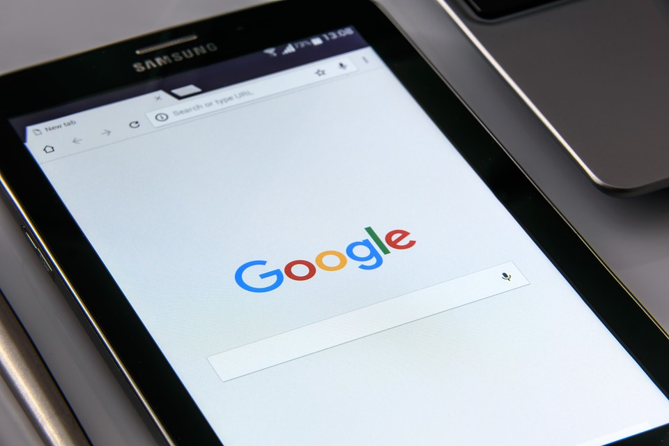 Google.  Image shows the word Google and a search bar on a smartphone screen.