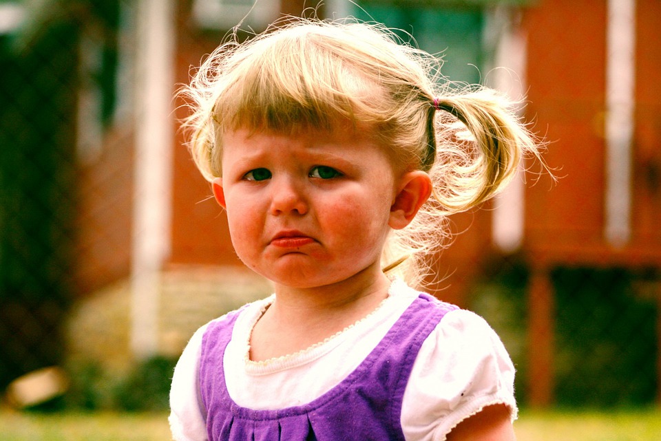 tantrums.  Image shows a young girl with blonde hair tied up and looking like she's about to cry.