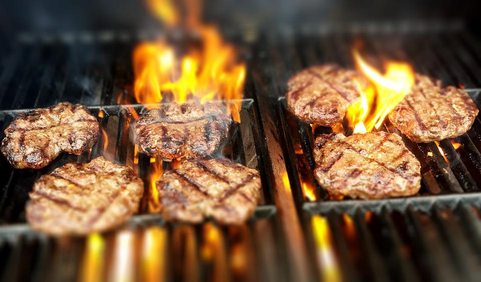 barbecue. Image shows burgers on a barbecue grill.