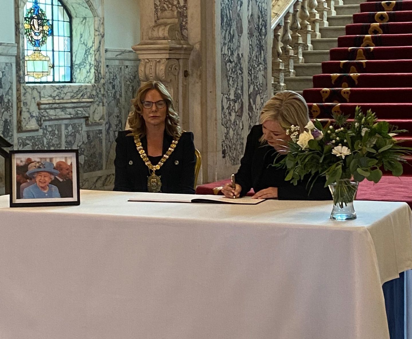 Sinn Fein's Michelle O'Neill (right) signs a book of condolence for Britain's Queen ELizabeth II at Belfast City Hall. 