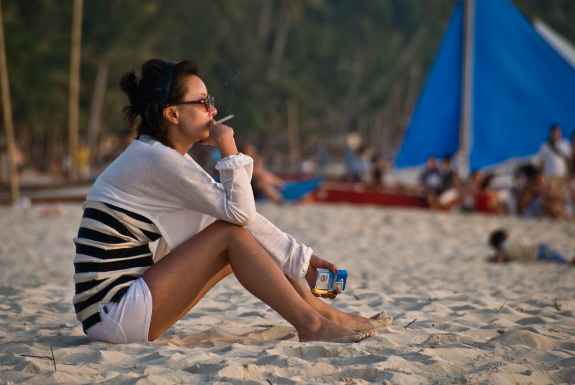 Girl smoking on White Beach, Boracay, Philippines.