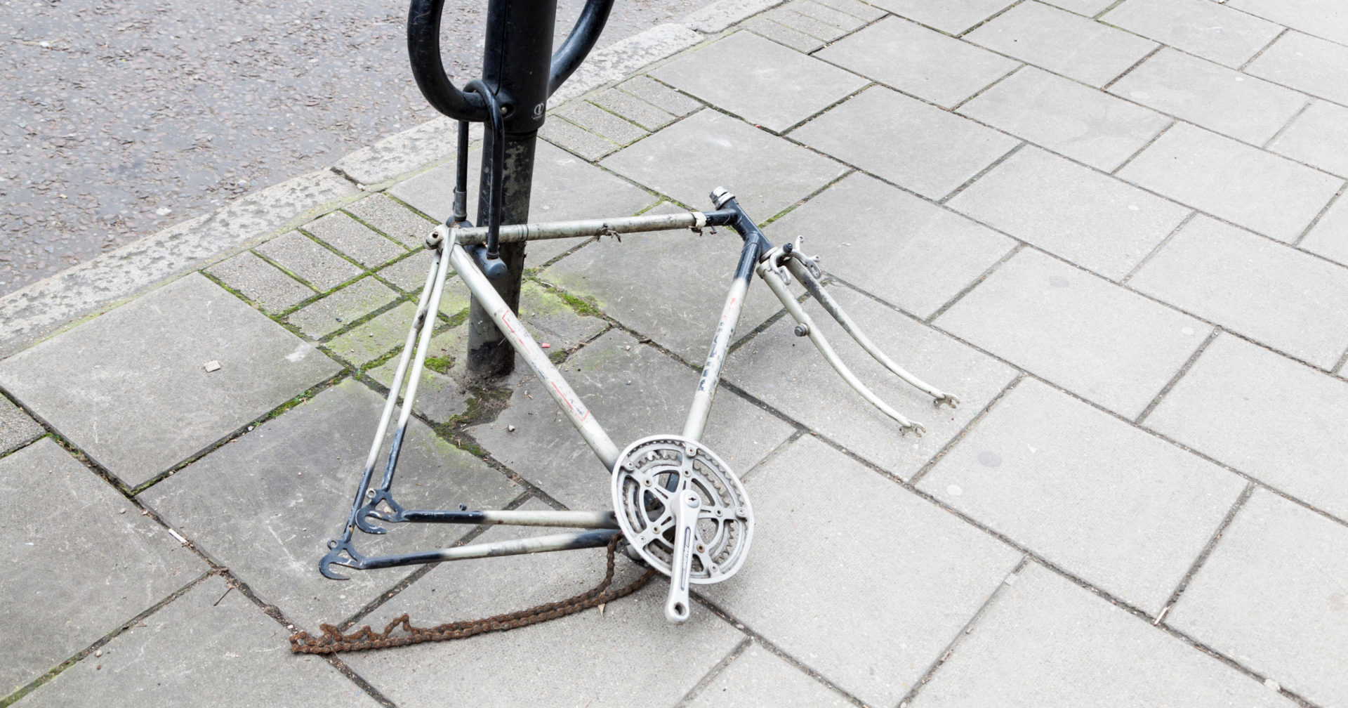 The frame of a locked bicycle left behind by thieves.