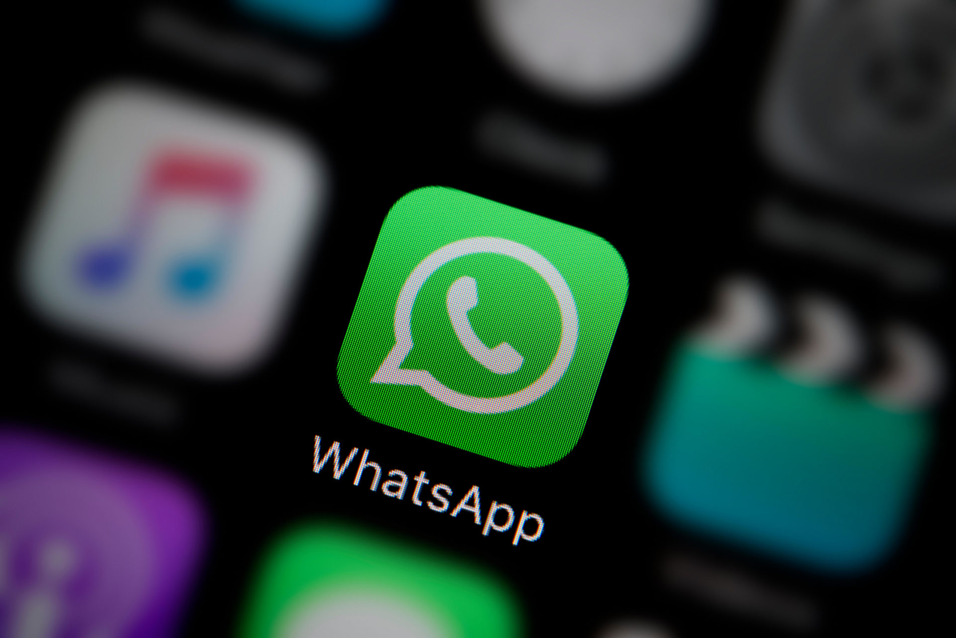 A close-up shot of the WhatsApp app icon on the screen of a smart phone