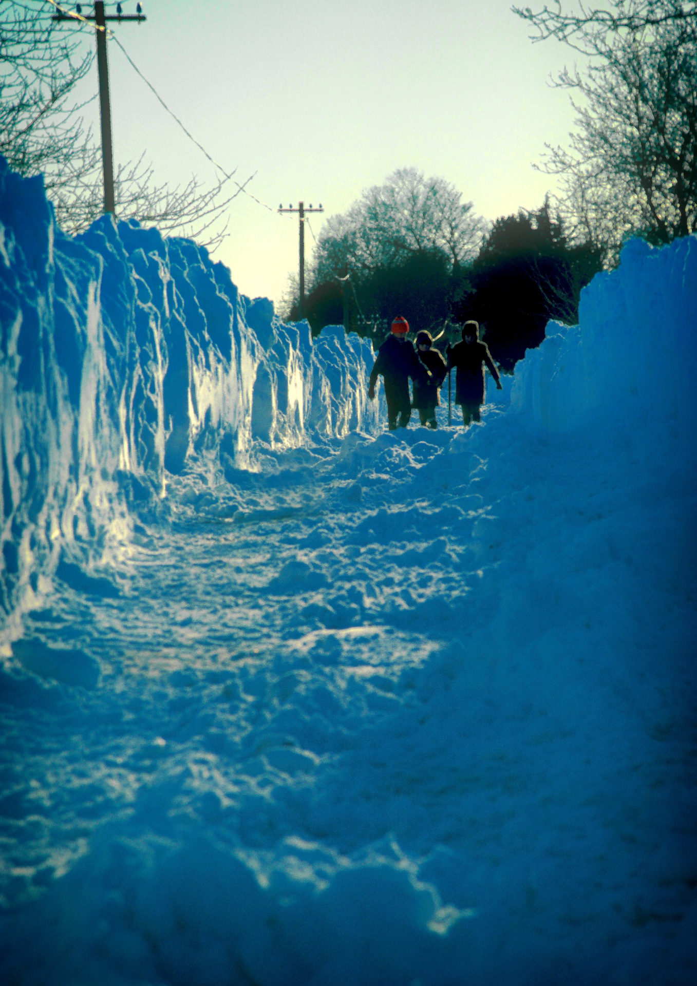 Children walking down a partially cleared country road four miles north of Ratoath, County Meath, Ireland following the blizzard of 1982.