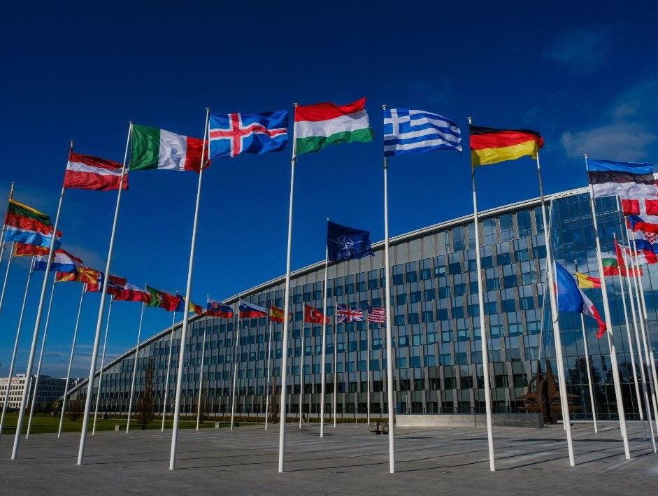 A NATO flag flies surrounded by flags of member states at the headquarters of the military alliance in Brussels. Belgium.