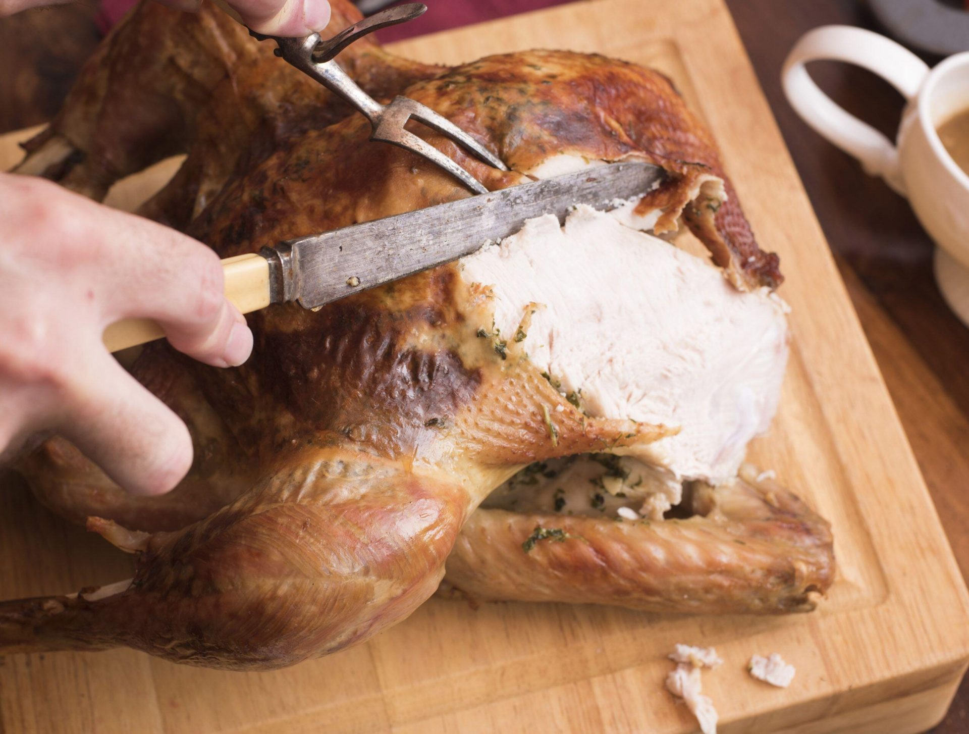 A man slicing meat from a Christmas turkey