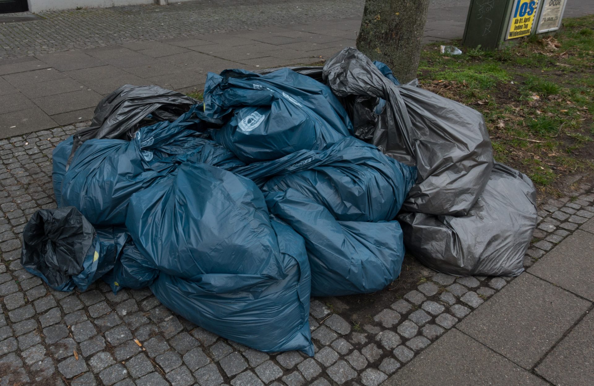 Full rubbish bags on a pavement.