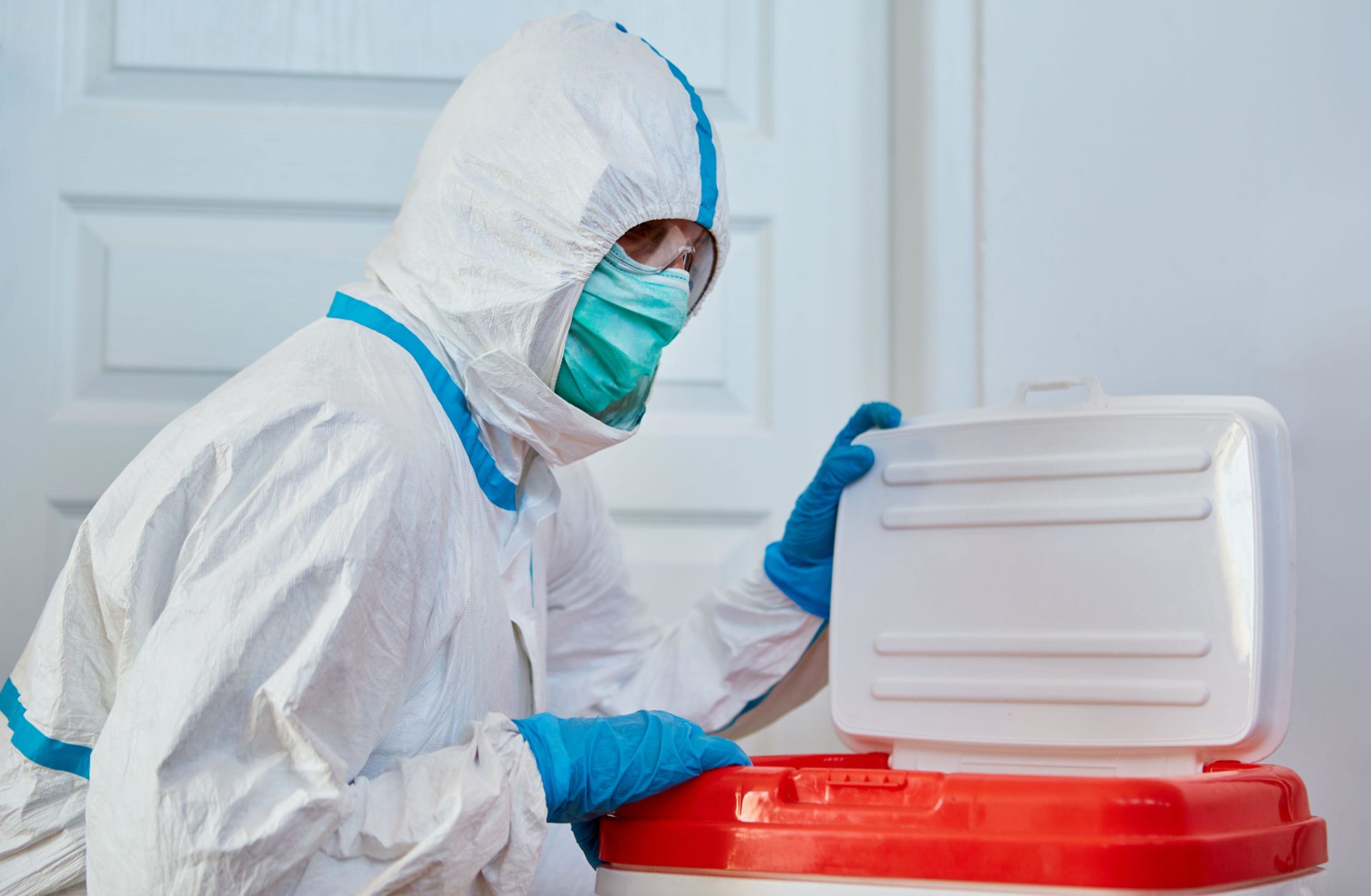 A surgeon in protective clothing with an organ donation in a box for transport, 23-4-20.