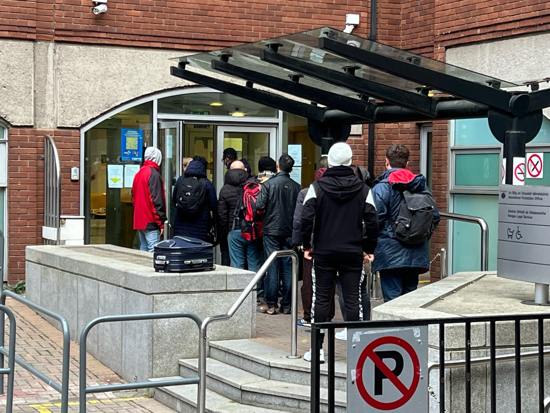 Main image shows asylum seekers queueing outside the Refugee Application Centre on Mount Street in Dublin.