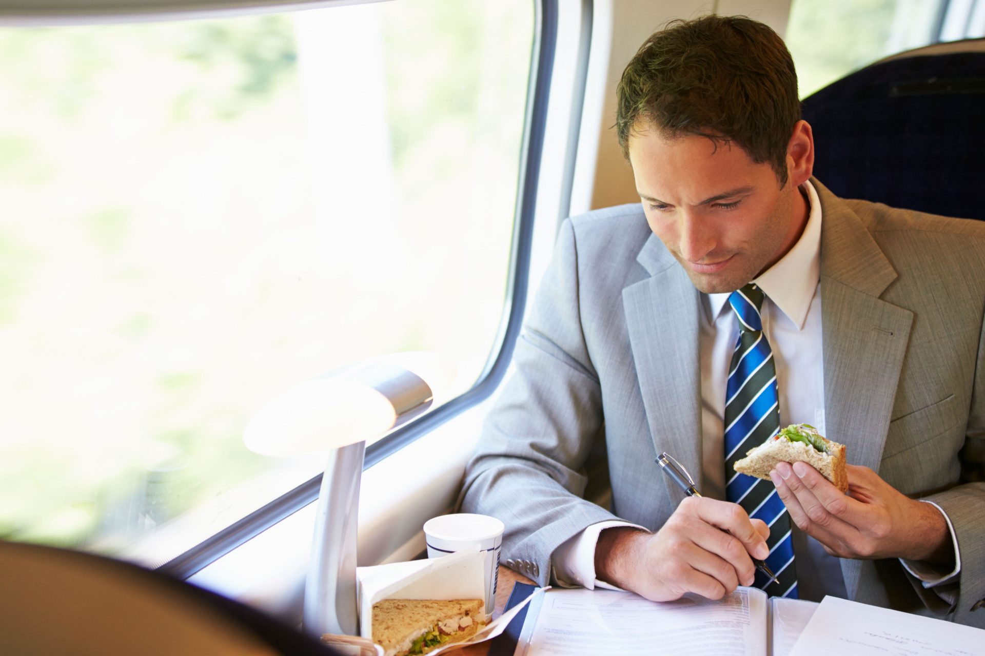 A man eats a sandwich on a train.