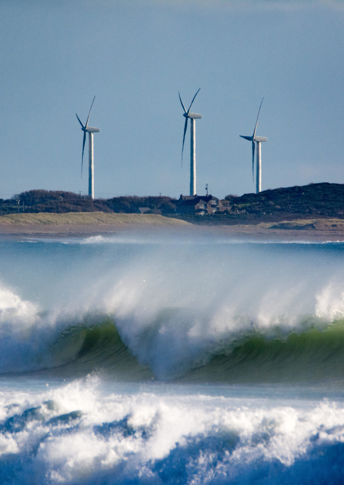 HDPJFY Wind turbines and powerful sea waves on the coast of Wexford in southern Ireland