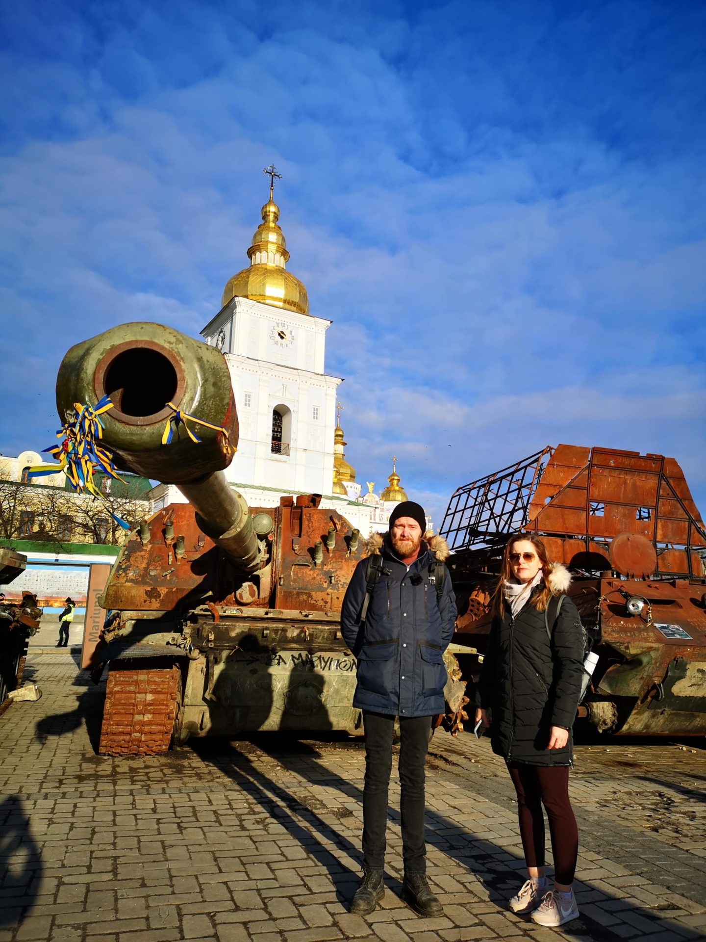 Sean Moncrieff and Aisling Moore beside destroyed Russian tanks and military equipment in Kyiv. 