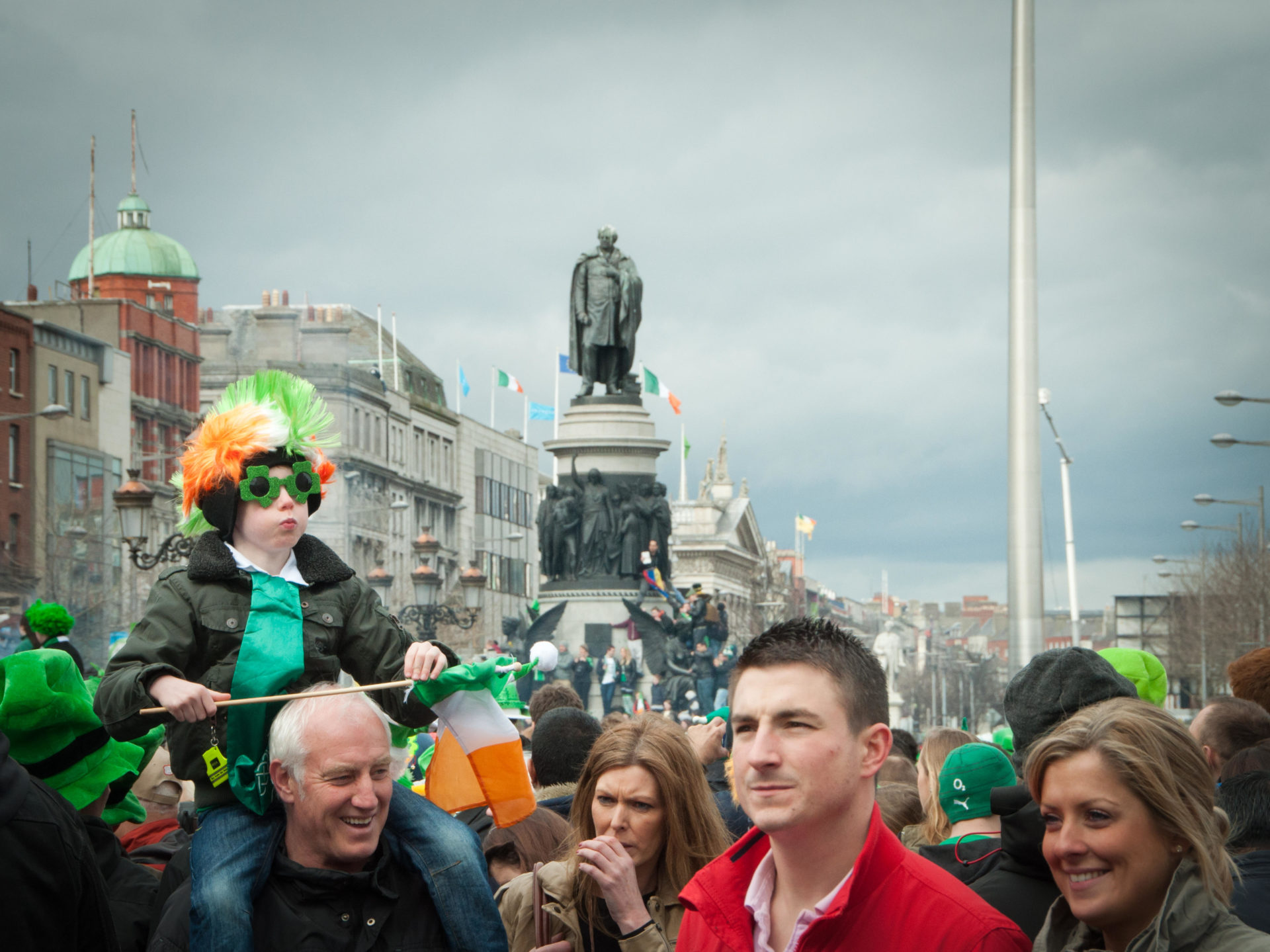Young boy on father's shoulders on St Patrick's day in Dublin.