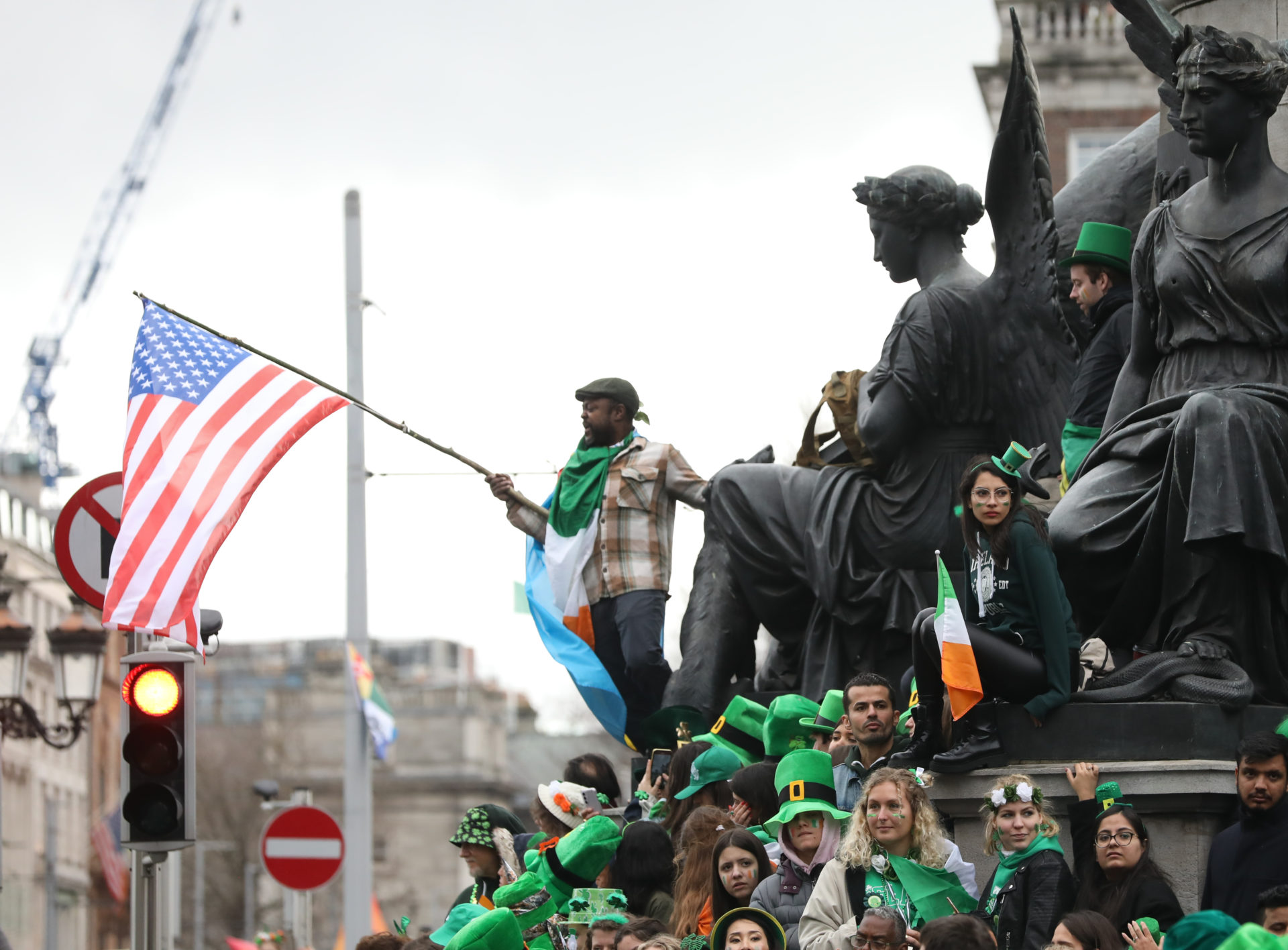 A man waving an American flag on O'Connell Street during the Saint Patrick's Day parade.